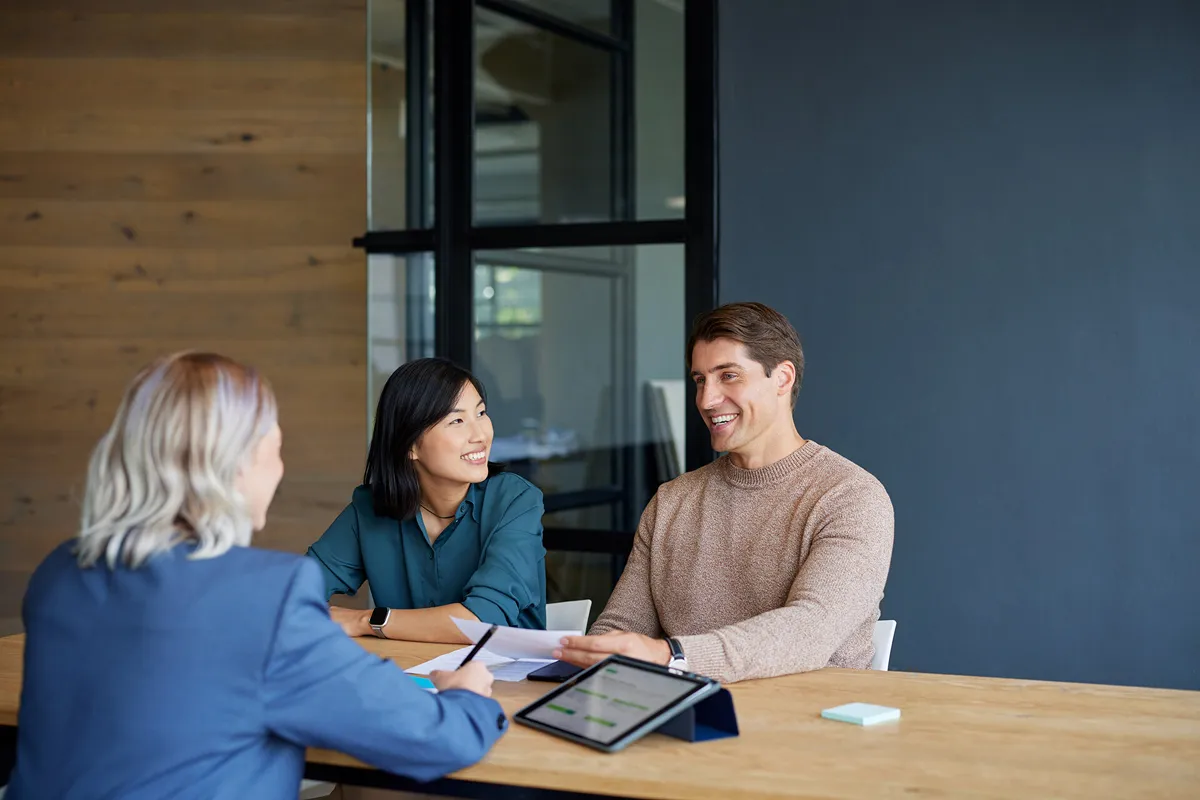 three people talking at a meeting 